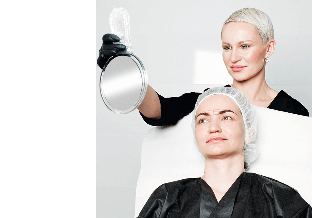 Elena Nikora International Trainer with client Elena Nikora International Trainer, holds a mirror in front of a client